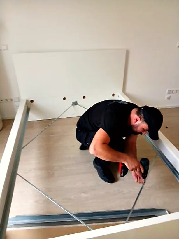Two-Spears-Mitarbeiter montiert ein Bettgestell