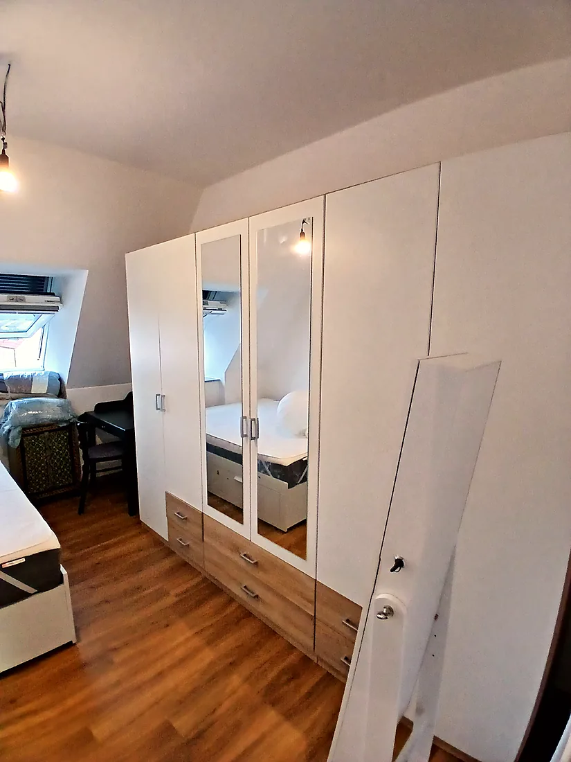 Fertig aufgebauter weißer Kleiderschrank mit Spiegeltüren