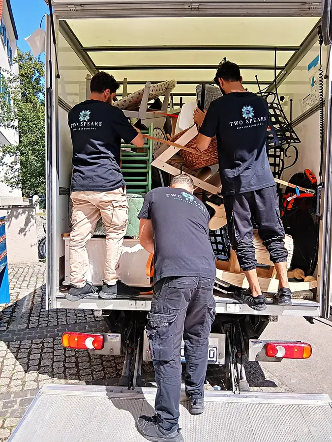 Team von Two Spears belädt einen Umzugs-LKW an der Straße