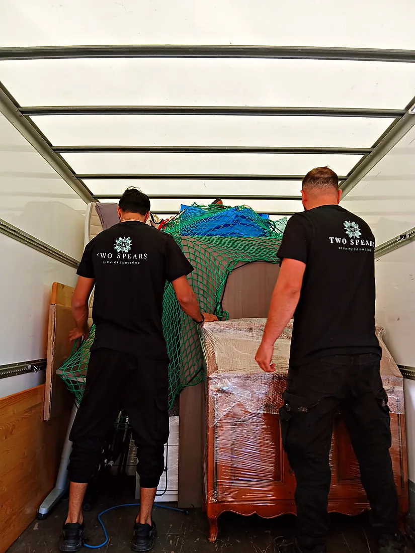 Zwei Two-Spears-Mitarbeiter verstauen Möbel im LKW