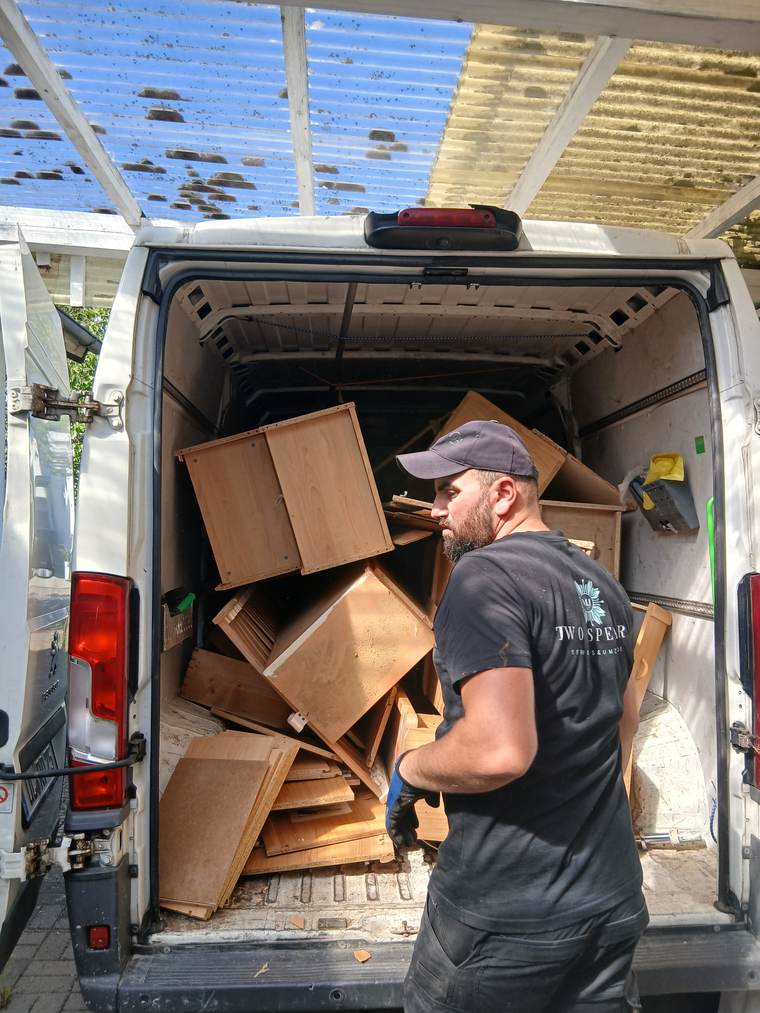 Two-Spears-Mitarbeiter im Firmen-Shirt beim Beladen des Transporters